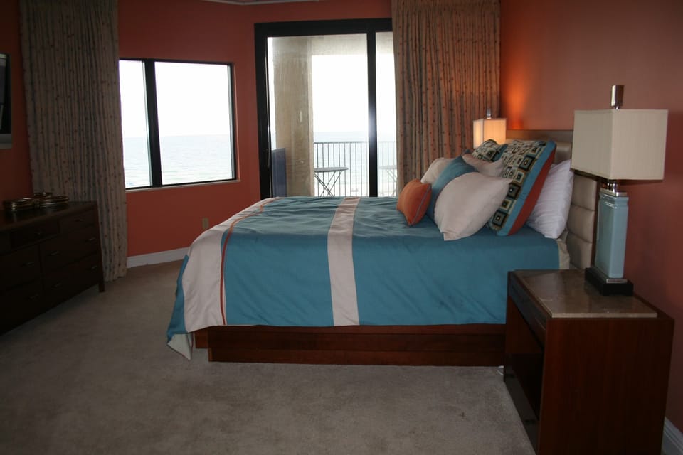 master bedroom with California king size bed and direct access to balcony