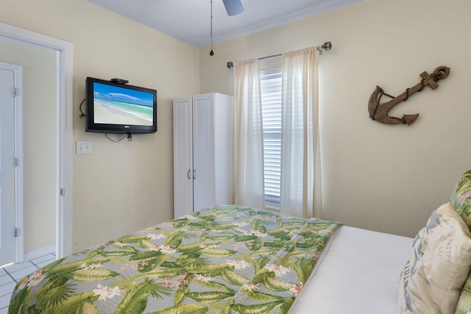 A comfortable bedroom with a smart TV and ample storage.