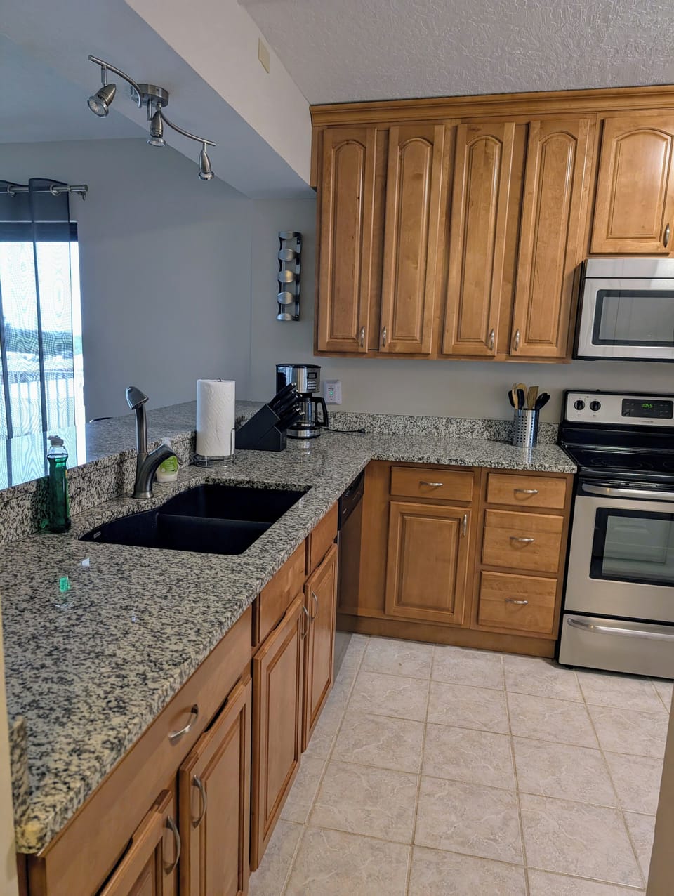 Kitchen with granite countertops, granite sink and stainless steel appliances