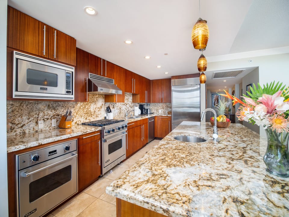 Fully equipped kitchen featuring stainless steel appliances, granite countertops, and ample space for meal preparation.