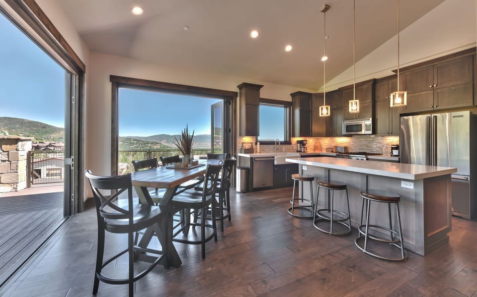 Dining for up to six at the table with additional seating at center island, balcony in season
