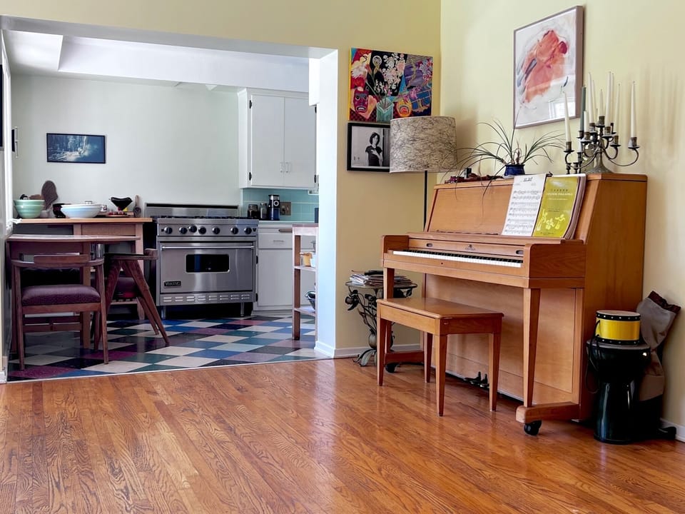 Piano in great room with kitchen showing on the left