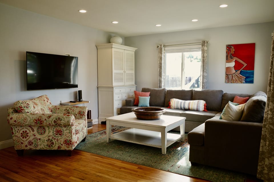 Living room equipped with a large couch and smart tv. 