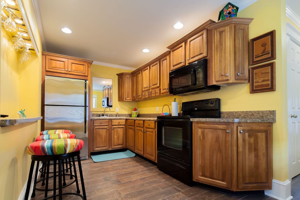 Galley kitchen, fully stocked with cooking utensils and plates