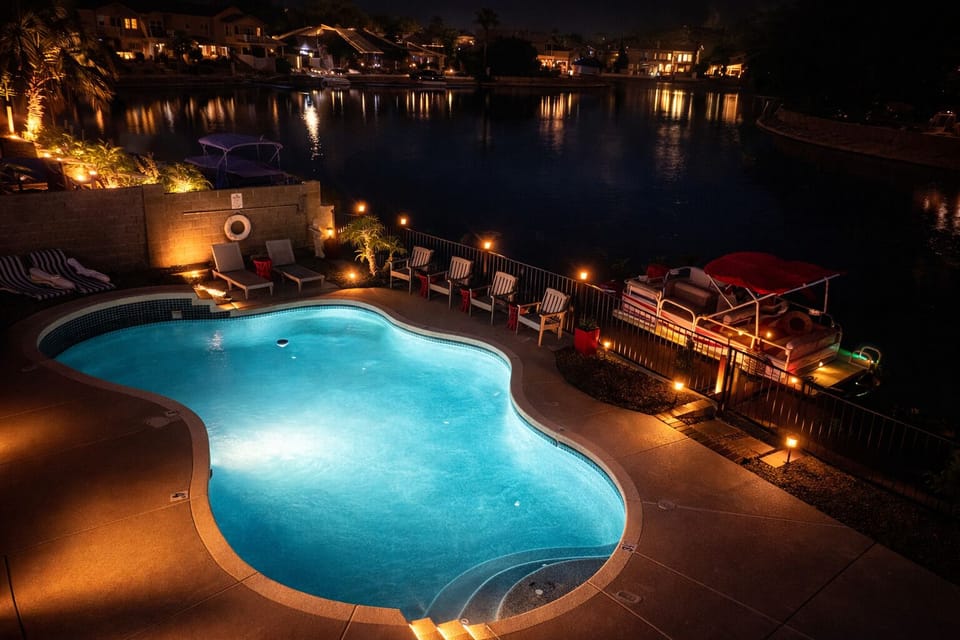 The illuminated luxurious pool glows against the night sky, inviting you in.