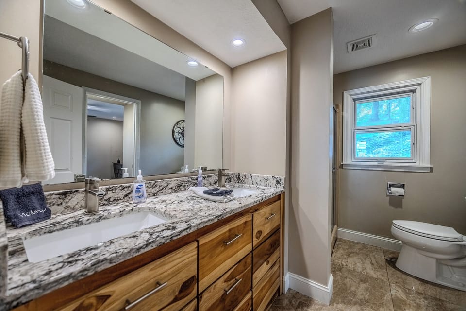 "Modern bathroom with dual sinks, granite countertops, and a spacious layout."