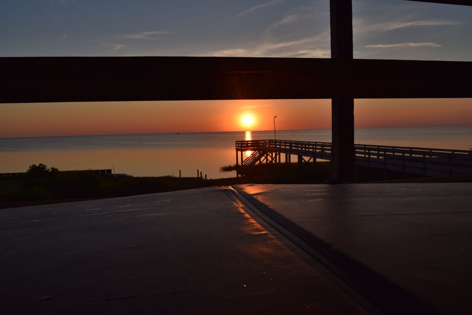 Hot tub cover on, sun sets over the Sound, mainland NC over the horizon.  