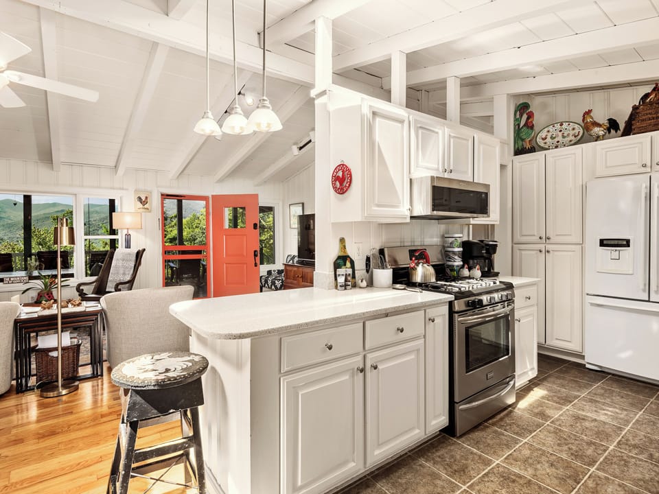Kitchen with quartz countertops, gas stove, double door fridge & microwave.
