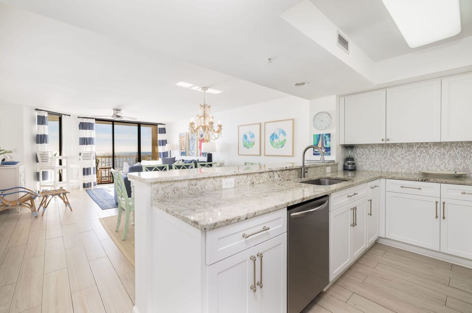 Upgraded kitchen with granite countertops, stainless steel appliances, and bar seating for casual dining