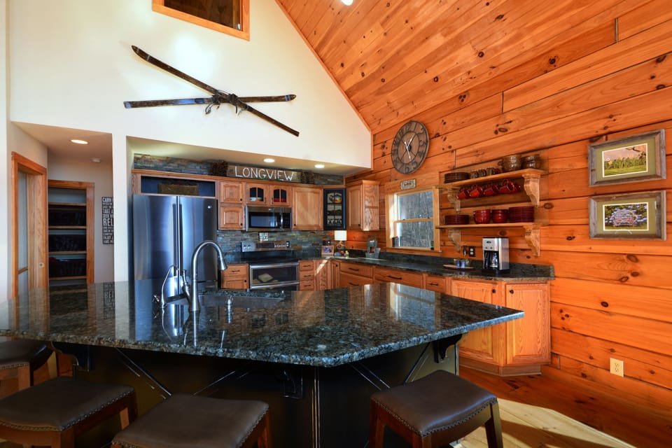 Large kitchen island with lots of counterspace and four bar stools.