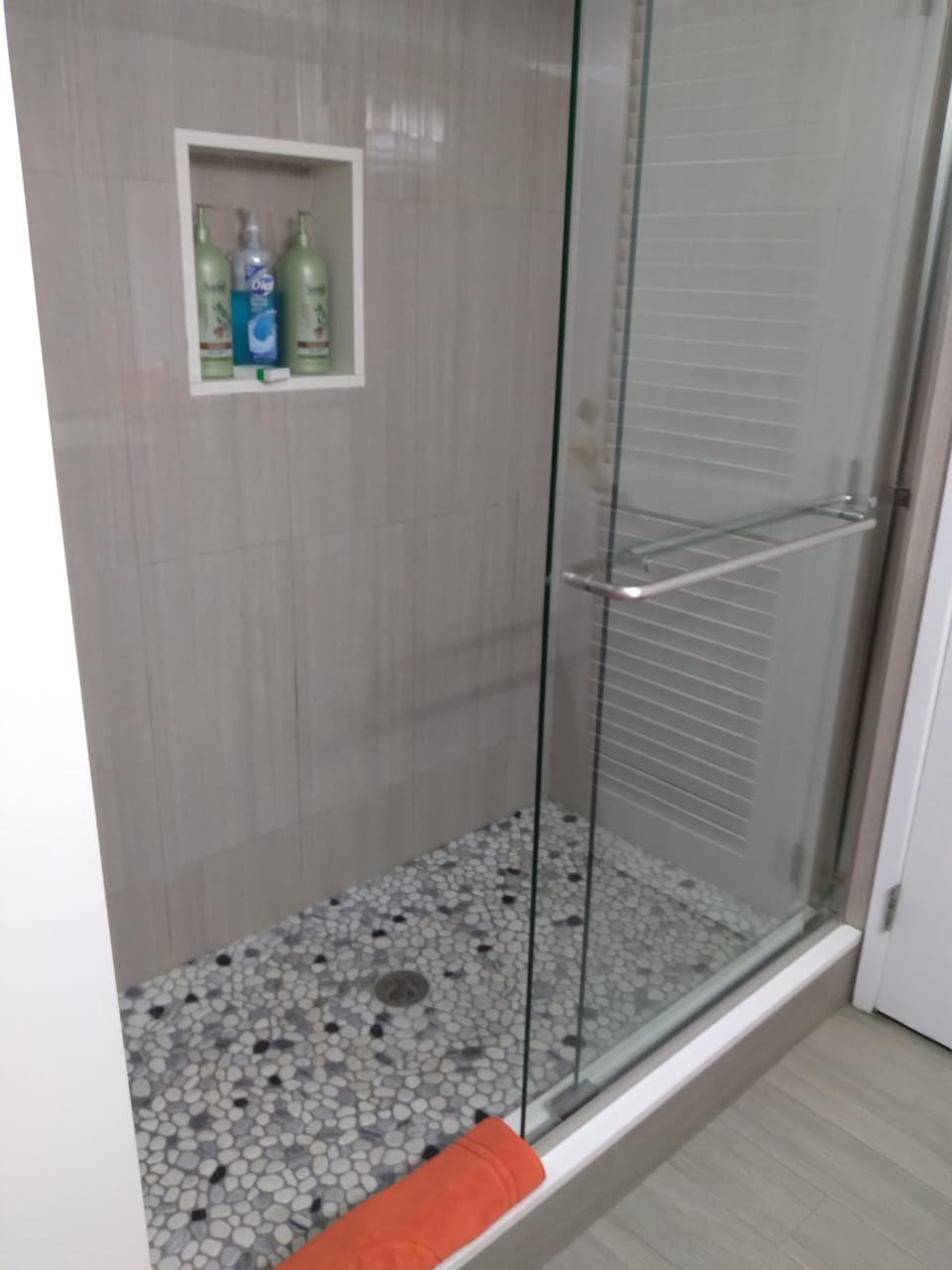 Large shower with rain showerhead & pebble tile flooring