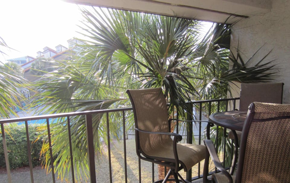 Beautiful view of the pool from balcony that has table and 4 chairs