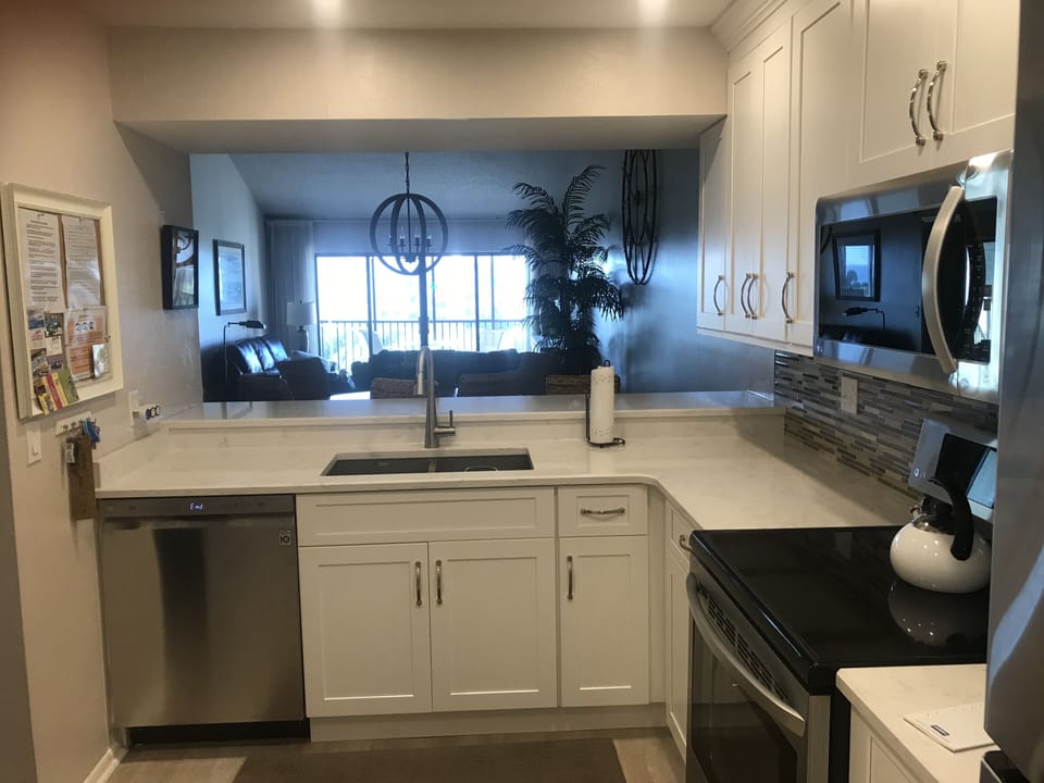 New cabinets, countertops, backsplash, appliances, sink, faucet, and flooring.