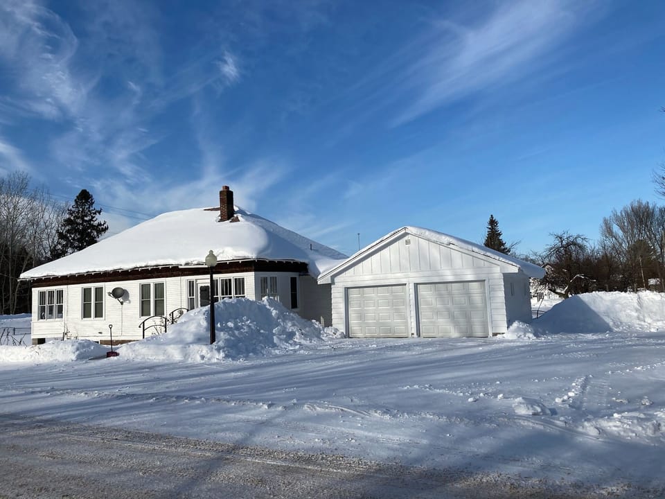 Plowed area along side of garage for large snowmobile trailers. 