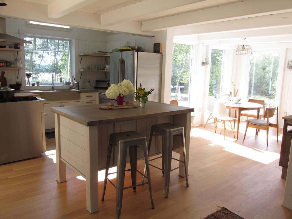 Large center island with additional seating. Dining room overlooking the cove .