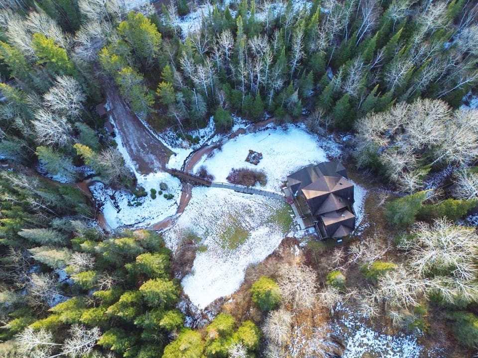 Airial View of home, fire pit, walkway to bridge and parking area
