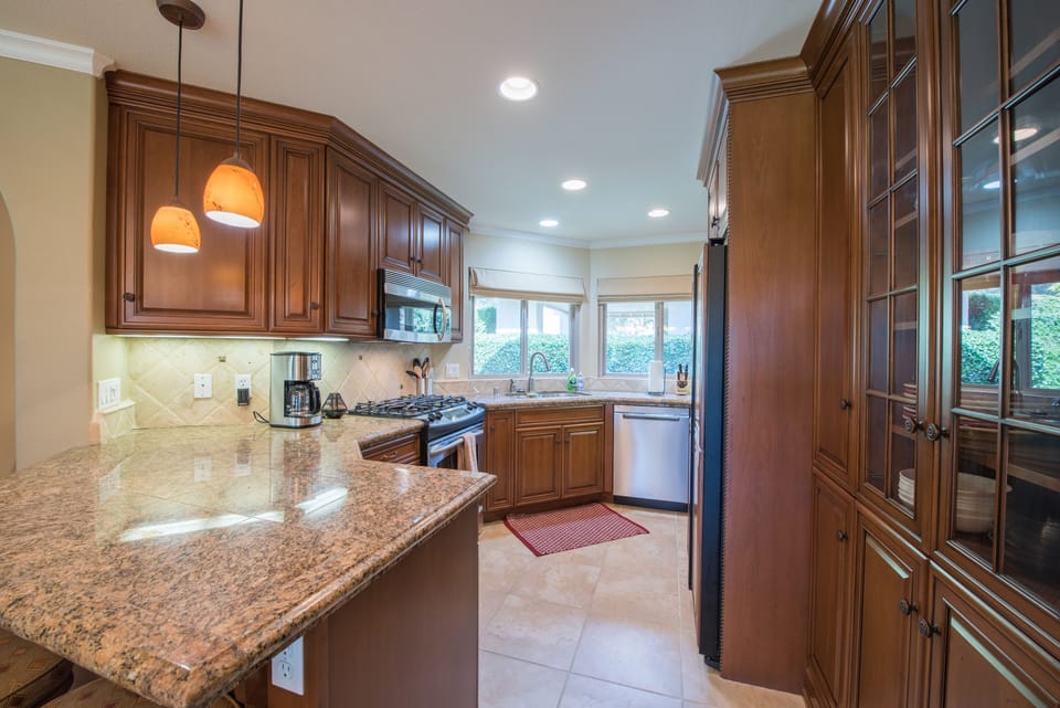 Upgraded kitchen has granite countertops and tile throughout