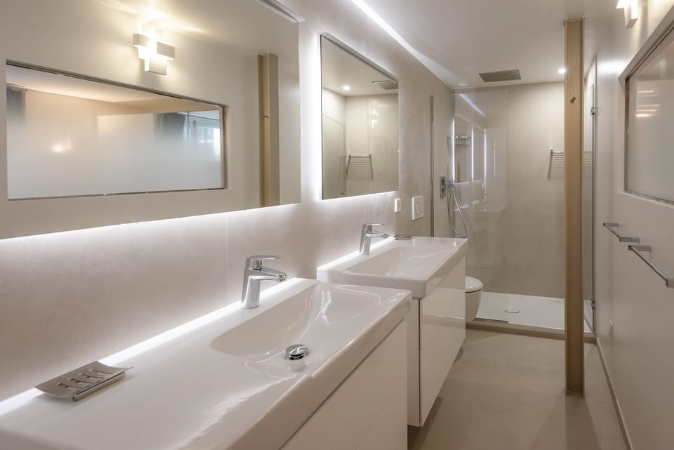 Bathroom 1 offers 2 vanity areas, a walk in shower and a toilet