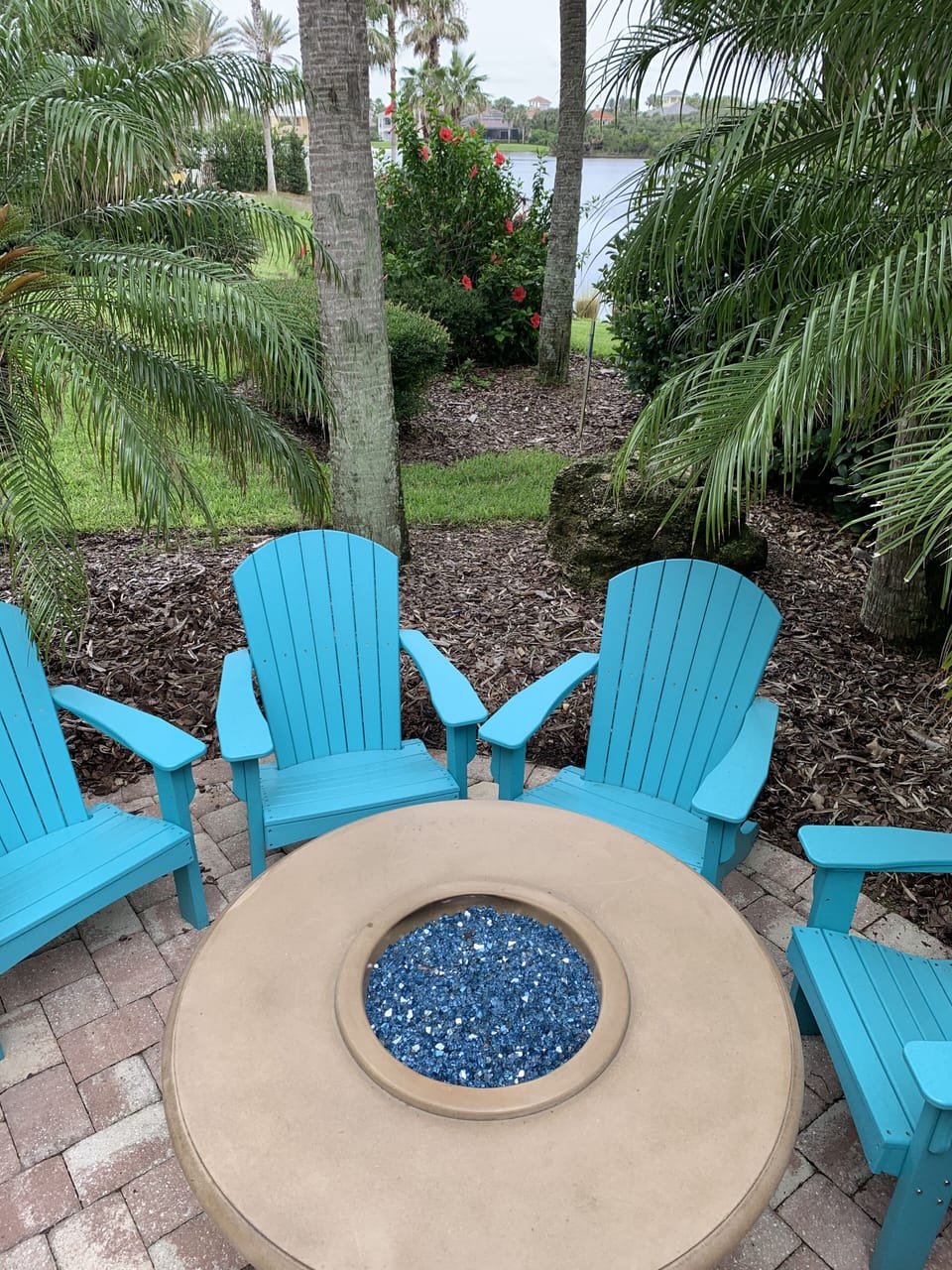 Firetable and adirondack chairs beside the lake.