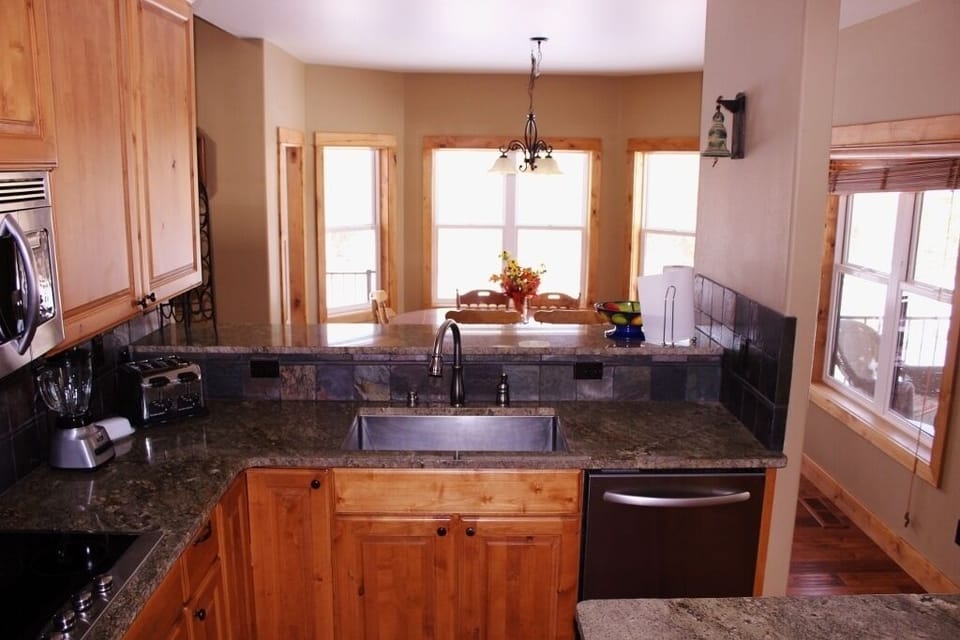 Kitchen looking into the dining room which overlooks the backyard and river