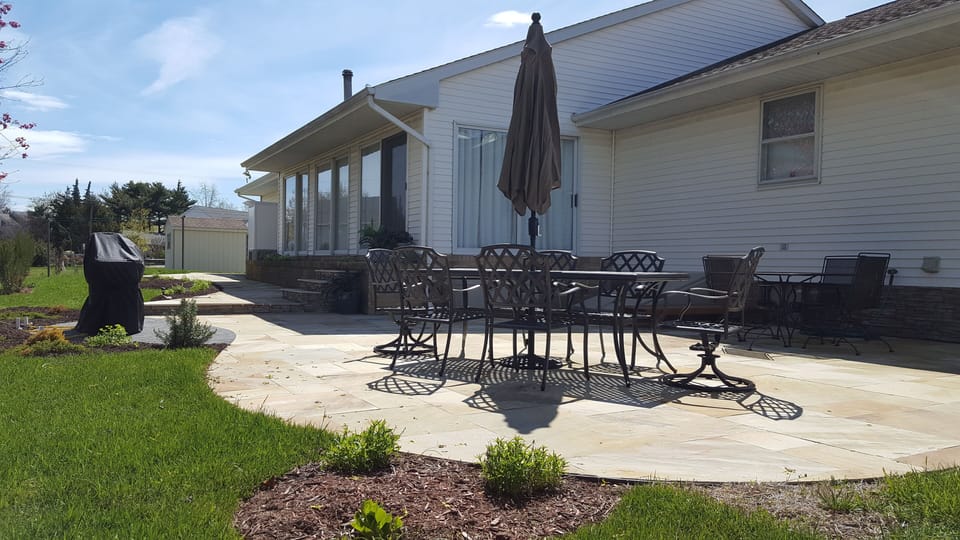 Patio with 2 tables with umbrellas.  Table #1 seating = 6, table #2 seating = 4.