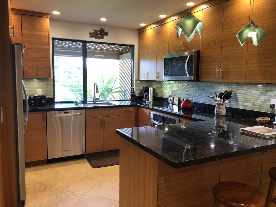 Fully stocked kItchen w/stainless steel appliances & a peninsula with seating.