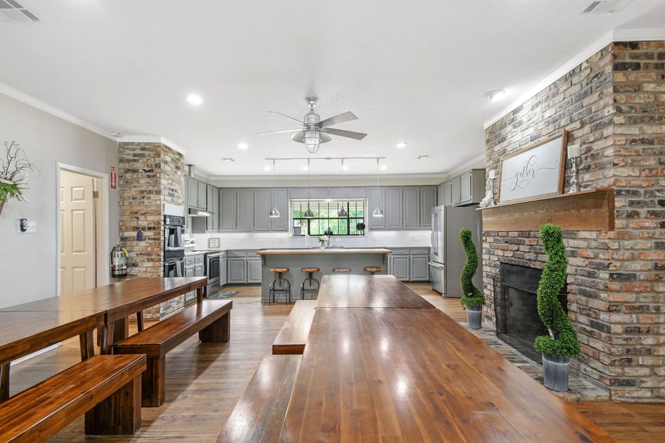 Kitchen includes 3ovens, stovetop, refrigerator, dishes. 4 farm tables.