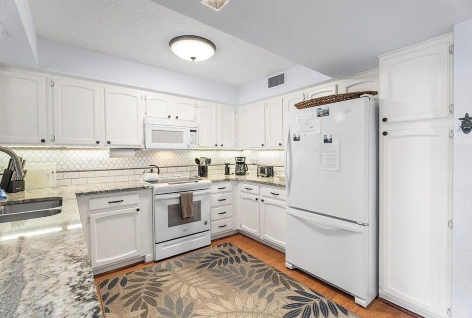 Kitchen with granite countertops, dishwasher, stove, microwave, and refrigerator