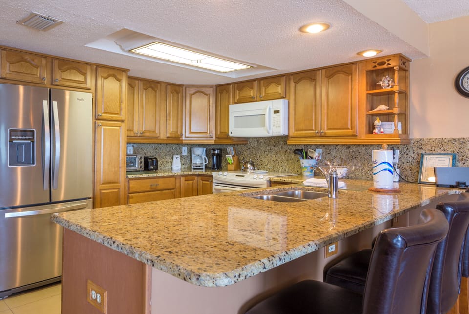 NEWLY REMODELED KITCHEN WITH ALL GRANITE COUNTERTOPS AND PLENTY OF POTS, PANS.