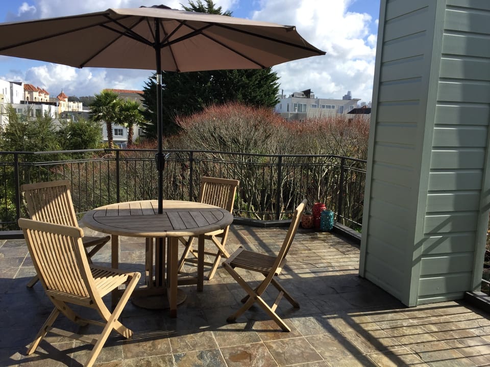 Enjoy morning coffee under the patio umbrella on the primary suite deck 