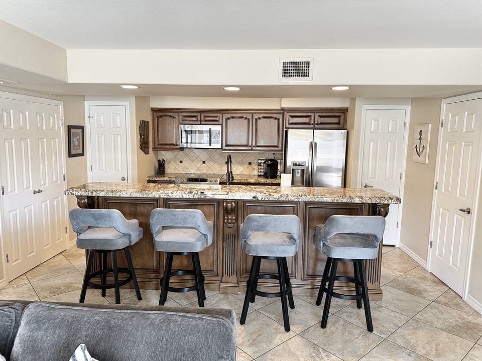 Kitchen with 4 comfy barstools.  Closets contain large pantry and washer/dryer.