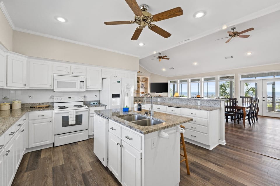 Bright and open kitchen with granite countertops and panoramic ocean views