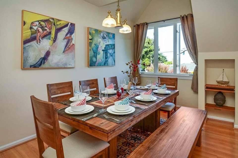 Dining table seats 10 on 6 chairs and a 4 person bench. It's open to the kitchen and living room too and looks out toward the ocean.