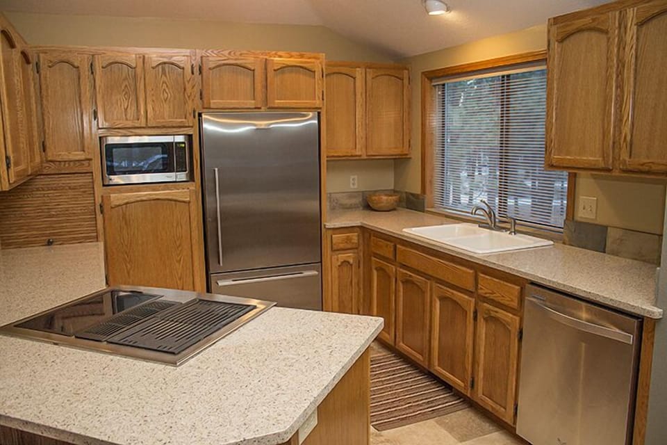Kitchen Features Slab Counters and Stainless Appliances