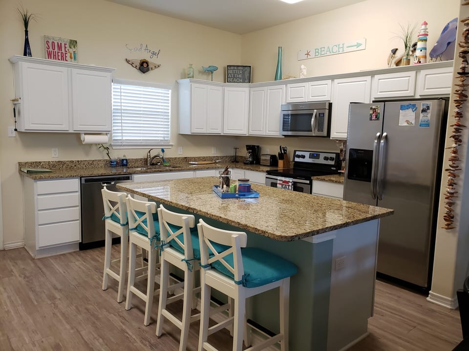 The fully equipped kitchen has a large island with seating for 4 more. 