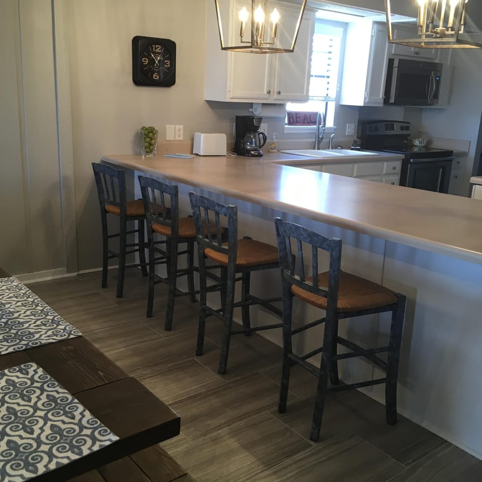 Bar seats four next to a large table that can seat  8