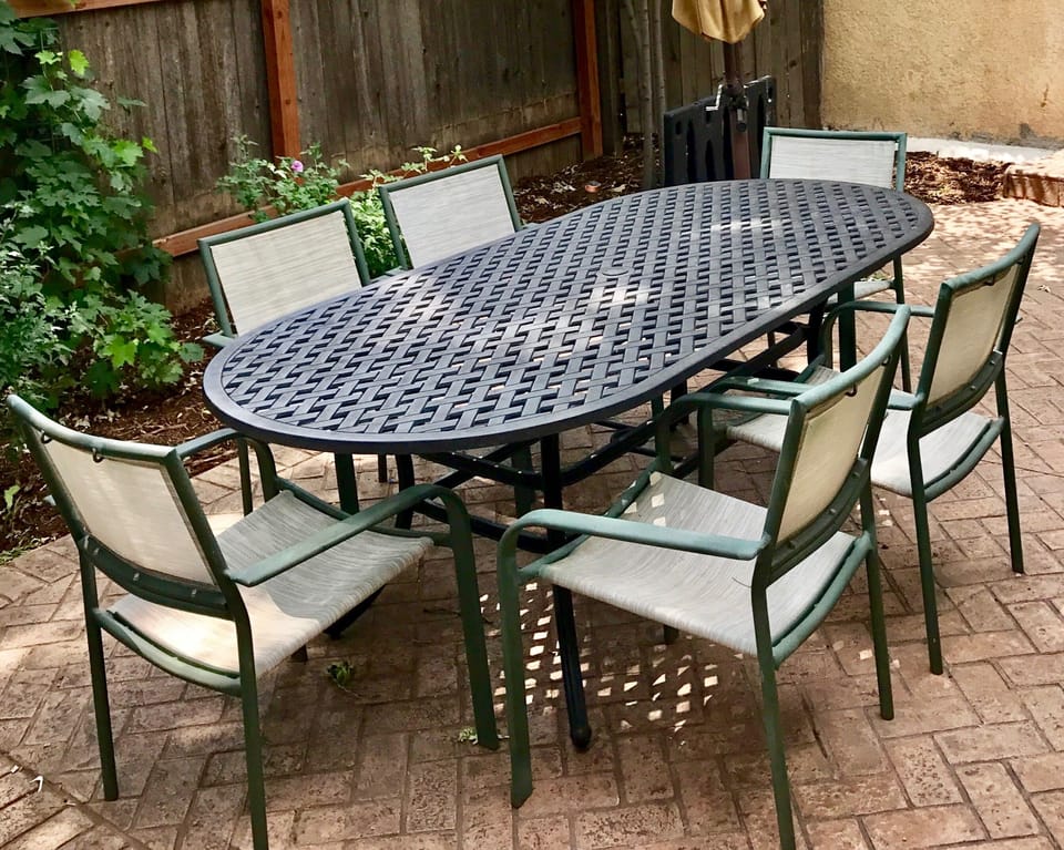 This large oval metal table is perfect for meals and relaxing on the patio. 