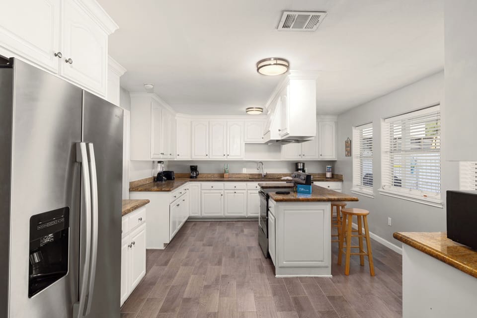 Large kitchen with additional bar seating and stainless steel appliances
