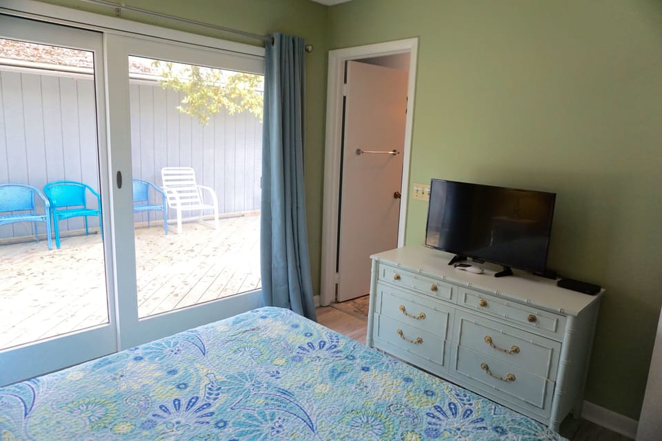 Queen bedroom also features a chest to store belongings and a TV.