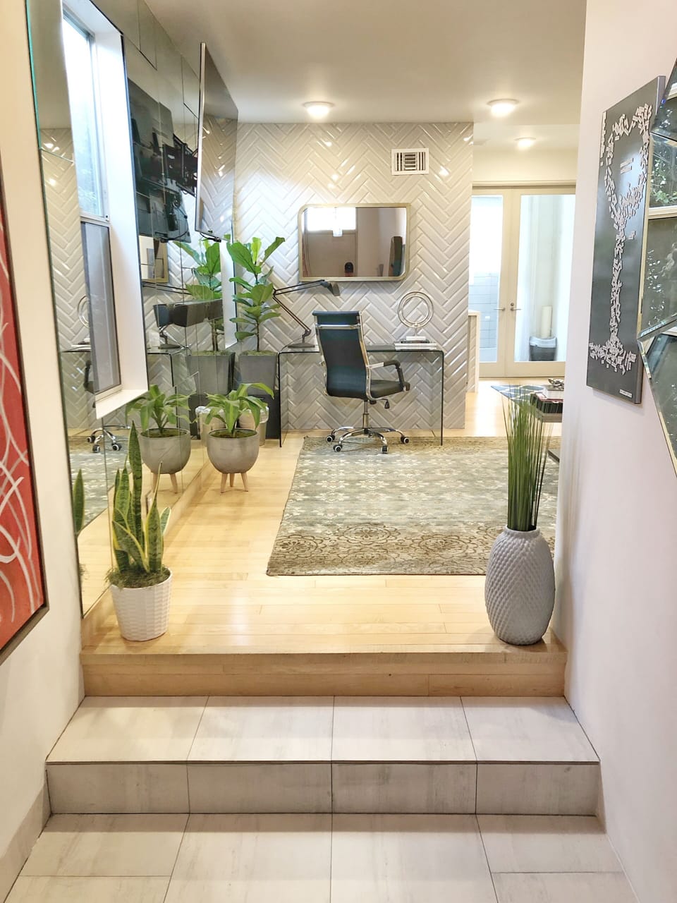 Stone entry with large scale art, executive desk and 70" TV 
