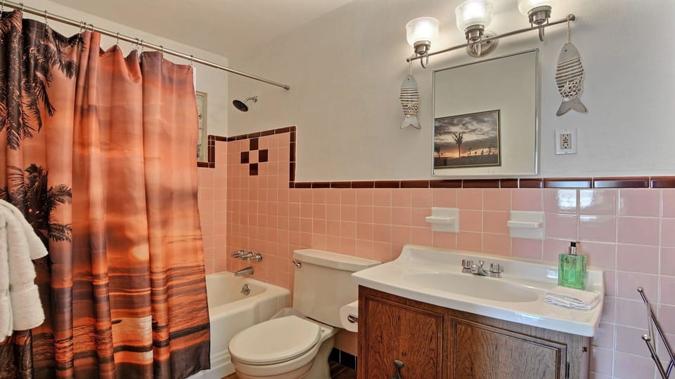 Cool retro 1950’s subway tiles in shared full bathroom with bathtub / shower.