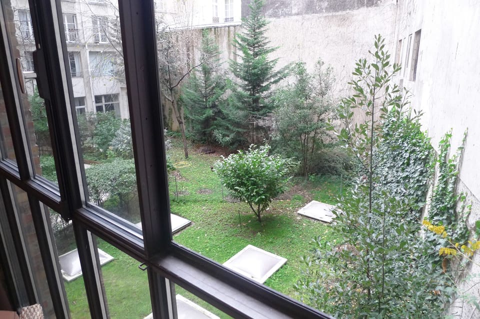 View over the greeneries in the quiet courtyard from the bay window