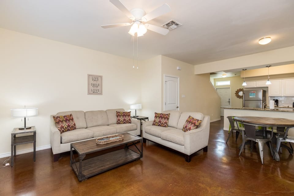 Unwind in your spacious open-plan living area with plush seating, gleaming polished floors, and modern touches throughout.