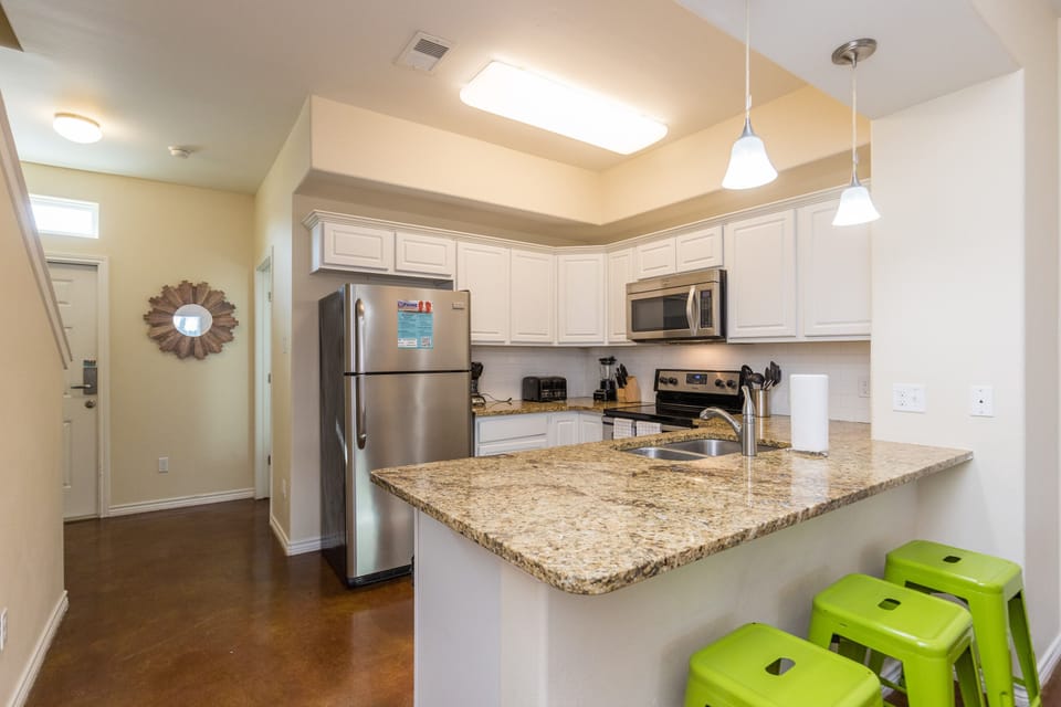 Cook up your favorite meals in this bright, modern kitchen featuring granite counters, stainless appliances, and cheerful breakfast bar seating.