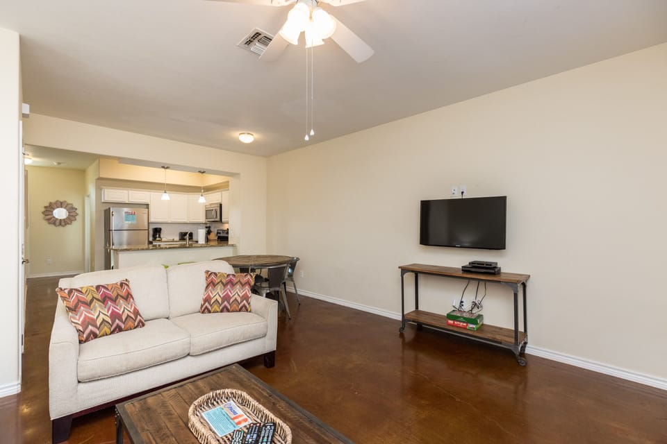 Unwind in your bright living space with a comfy sofa, flat-screen TV, and open kitchen - perfect for relaxing after exploring.