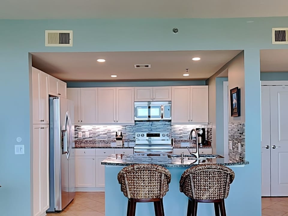 Well-equipped kitchen with 2021 LG appliances, granite, & mosaic backsplash