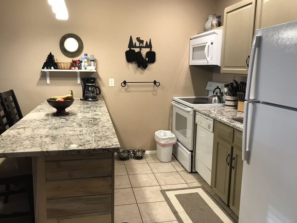 Kitchen w/ Granite countertops, microwave, fridge & newly renovated cabinets