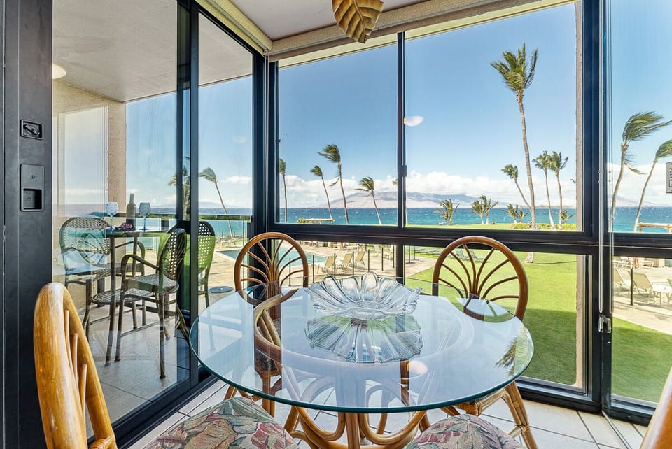 Dining area with round rattan & glass table w/4 matching chairs.