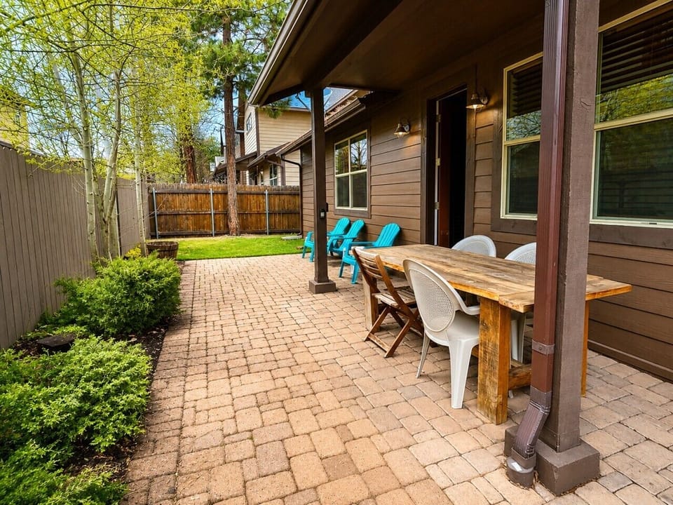 Fenced backyard patio with outdoor dining.