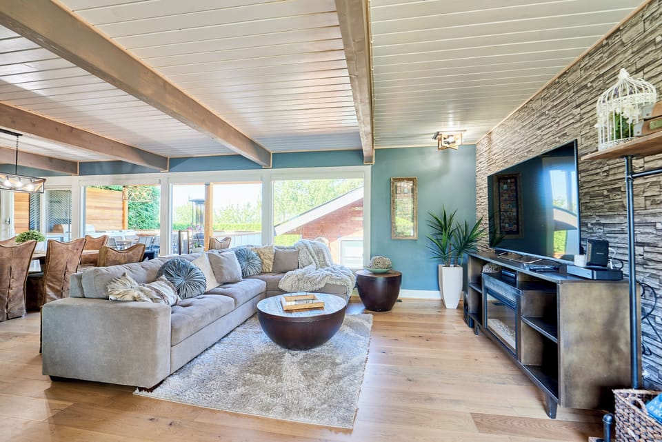 Light filled living room with cozy sectional, electric fireplace, and cable tv